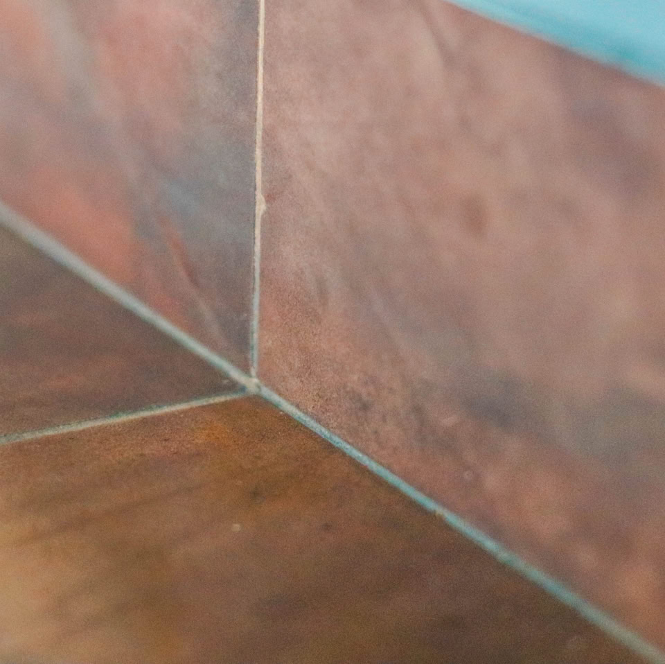 Corner of a room with brown wooden panels and a blue wall.